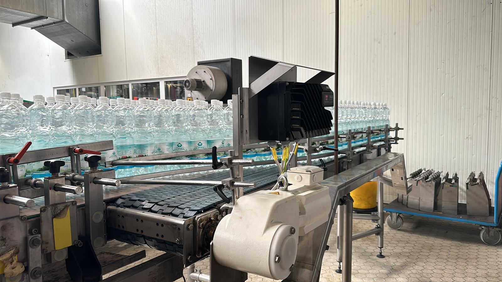 Verpackte Wasserflaschen auf einer Förderanlage in einer Abfüllproduktion