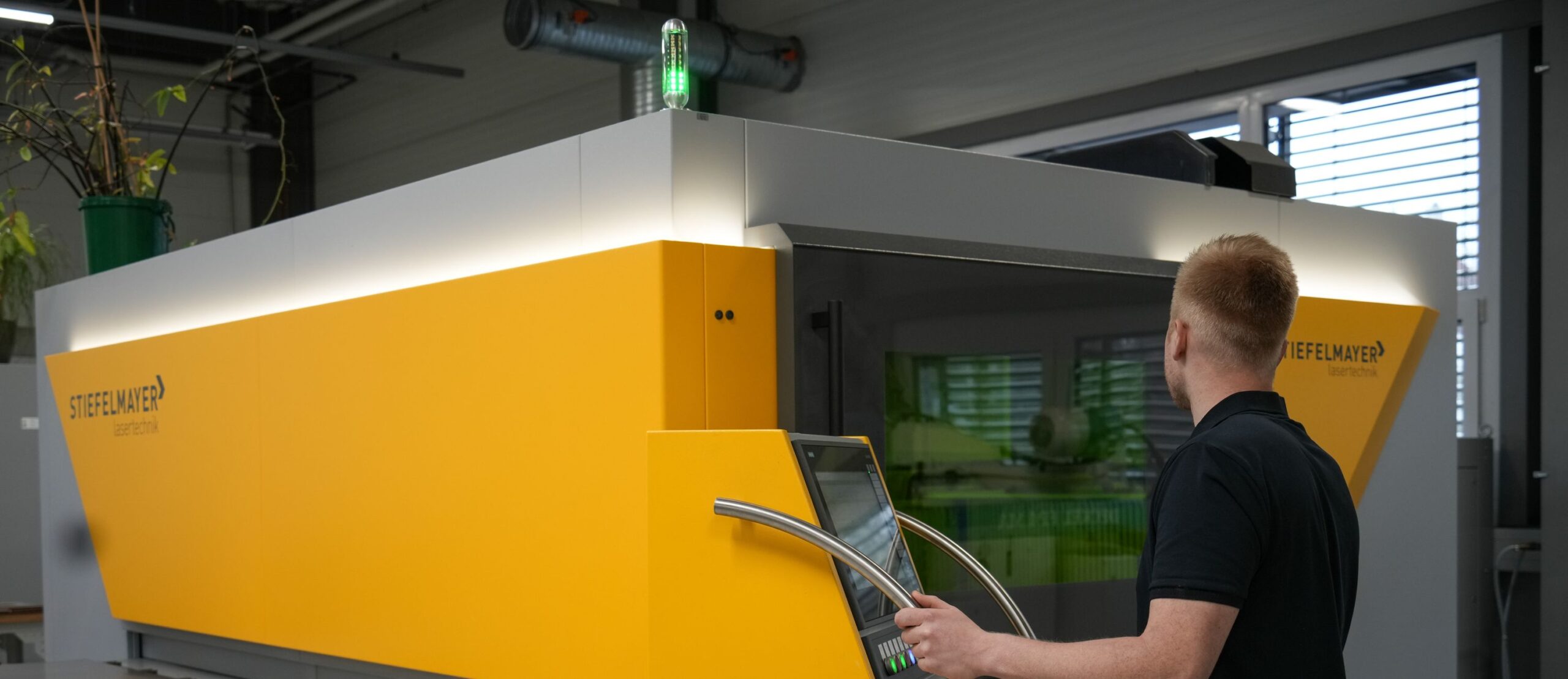 Mitarbeiter an Lasermaschine