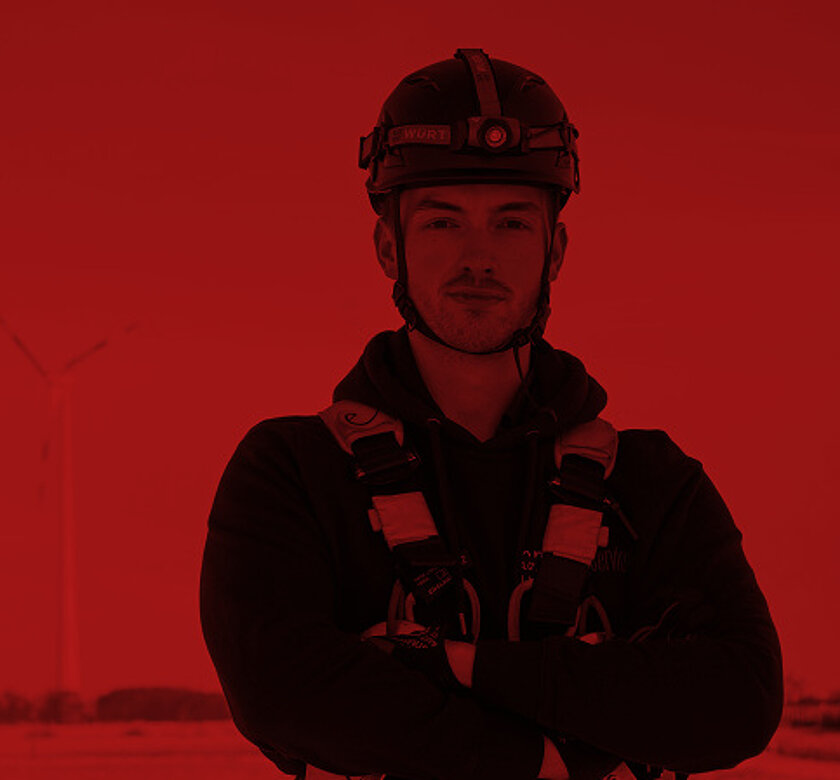 Mitarbeiter in Schutzausrüstung vor Windkraftanlagen
