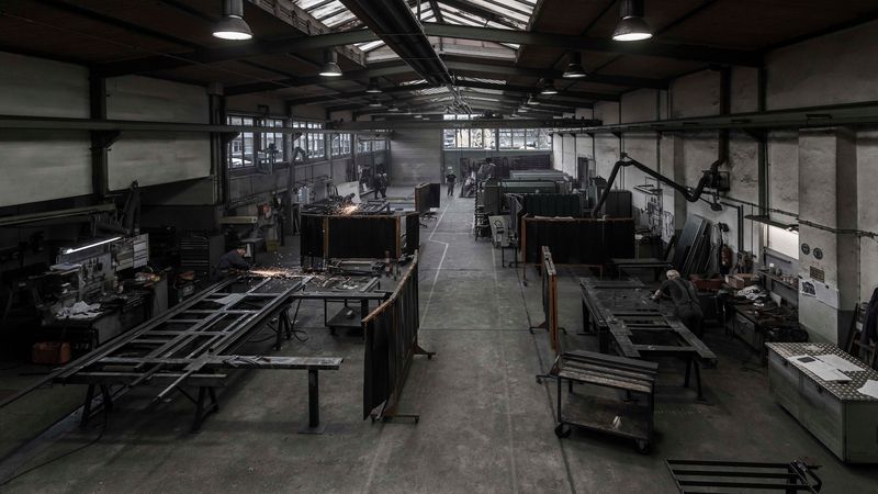 Werkstatt mit Arbeitstischen, Maschinen und Materialien