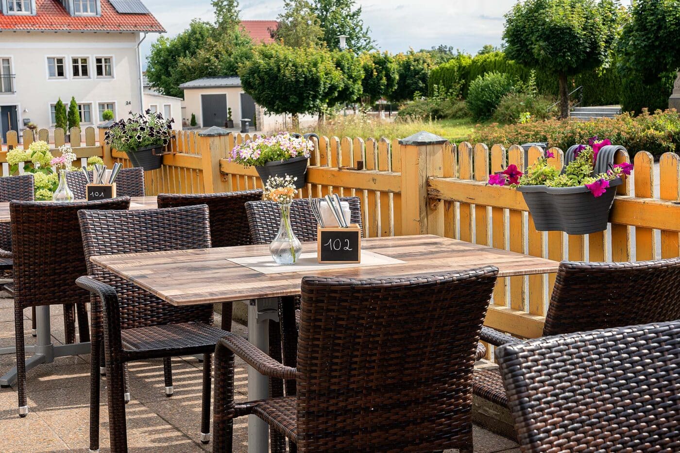 Terrassenmöbel mit klappbarem Aluminium-Tischgestell und stapelbaren Geflechtstühlen