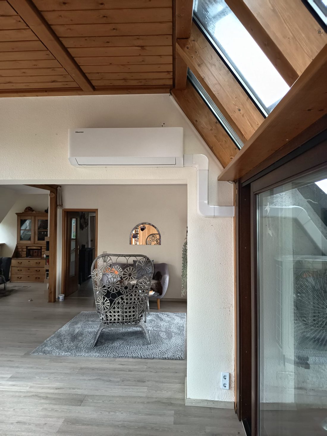 Wall-mounted air conditioner in attic with wooden ceiling